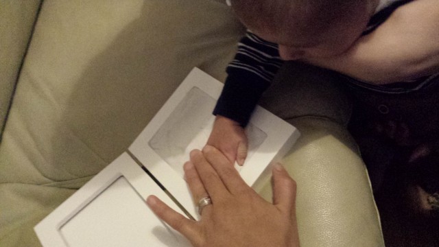 baby putting hand in clay